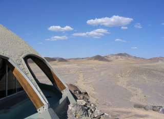 Illustration for article titled A House Shaped Like a Flying Saucer, Perched Atop a Volcano